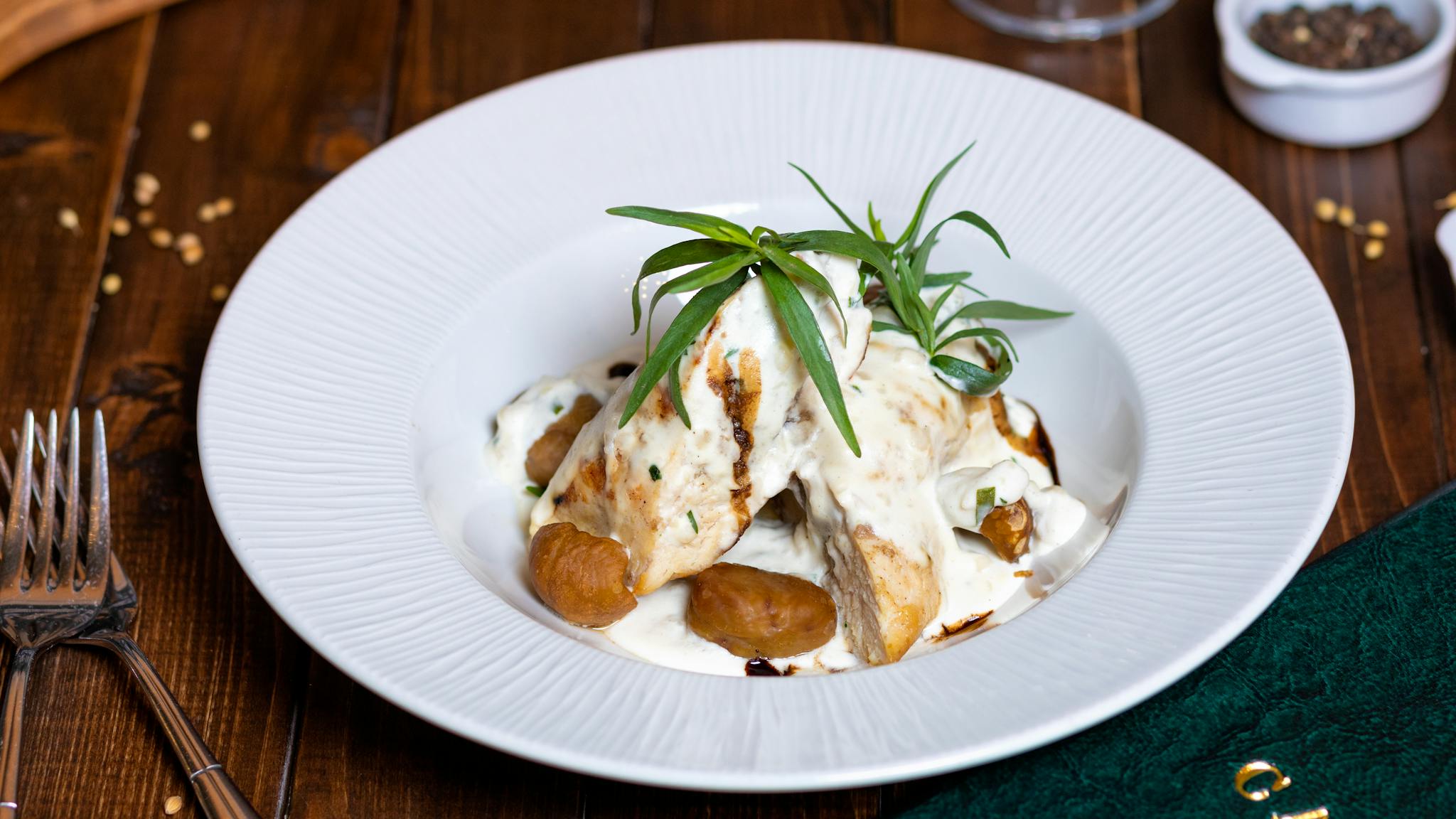 Delicious creamy chicken dish with herbs served on an elegant plate, perfect for fine dining experiences.